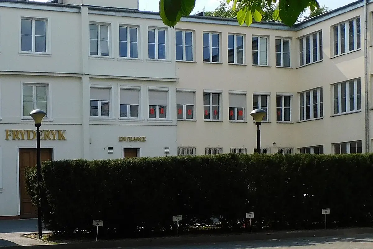 The entrance to Fryderyk Concert Hall: a pale façade with FRYDERYK in gold letters above a wooden door, and a courtyard in front.